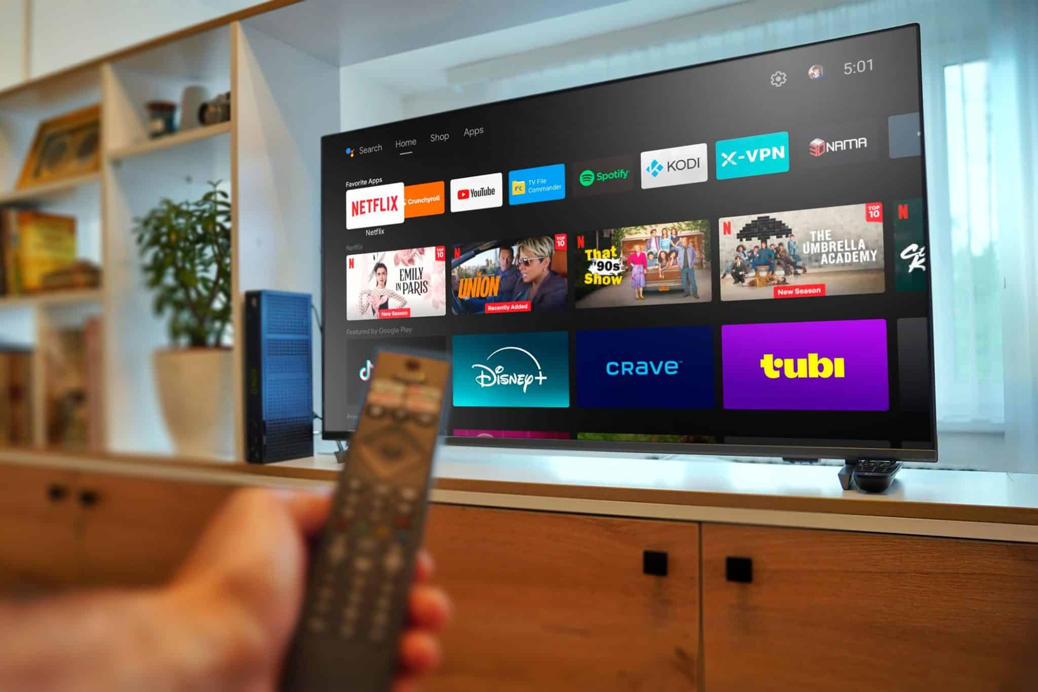 تلفزيون يعمل بنظام Android TV مع يد تحمل جهاز تحكم عن بُعد.