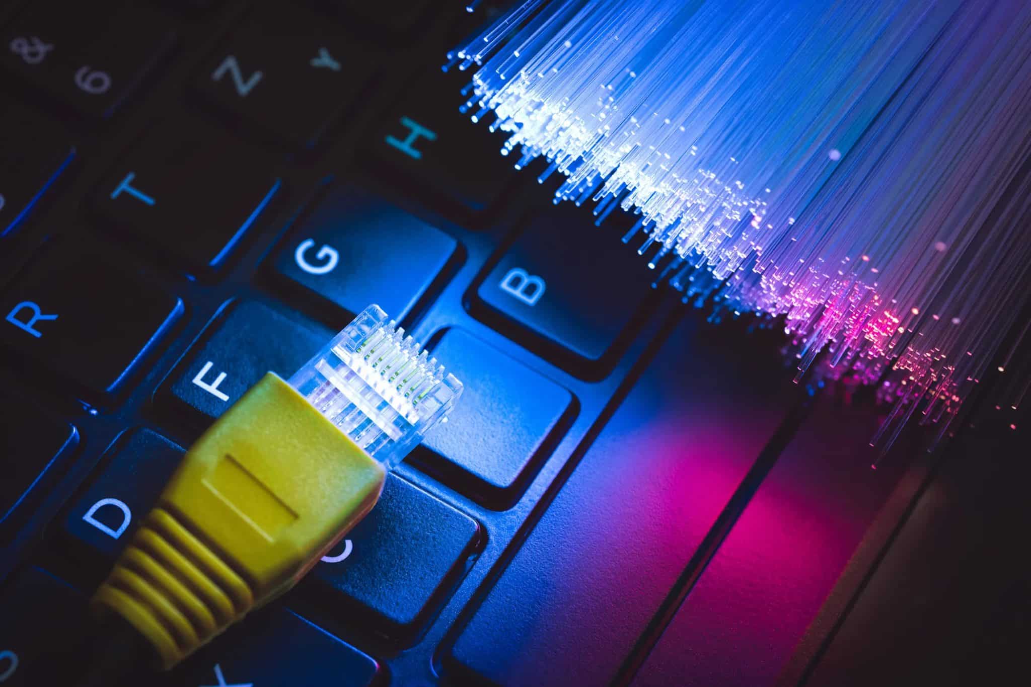 ethernet cable connector with fibre optic cables on laptop keyboard
