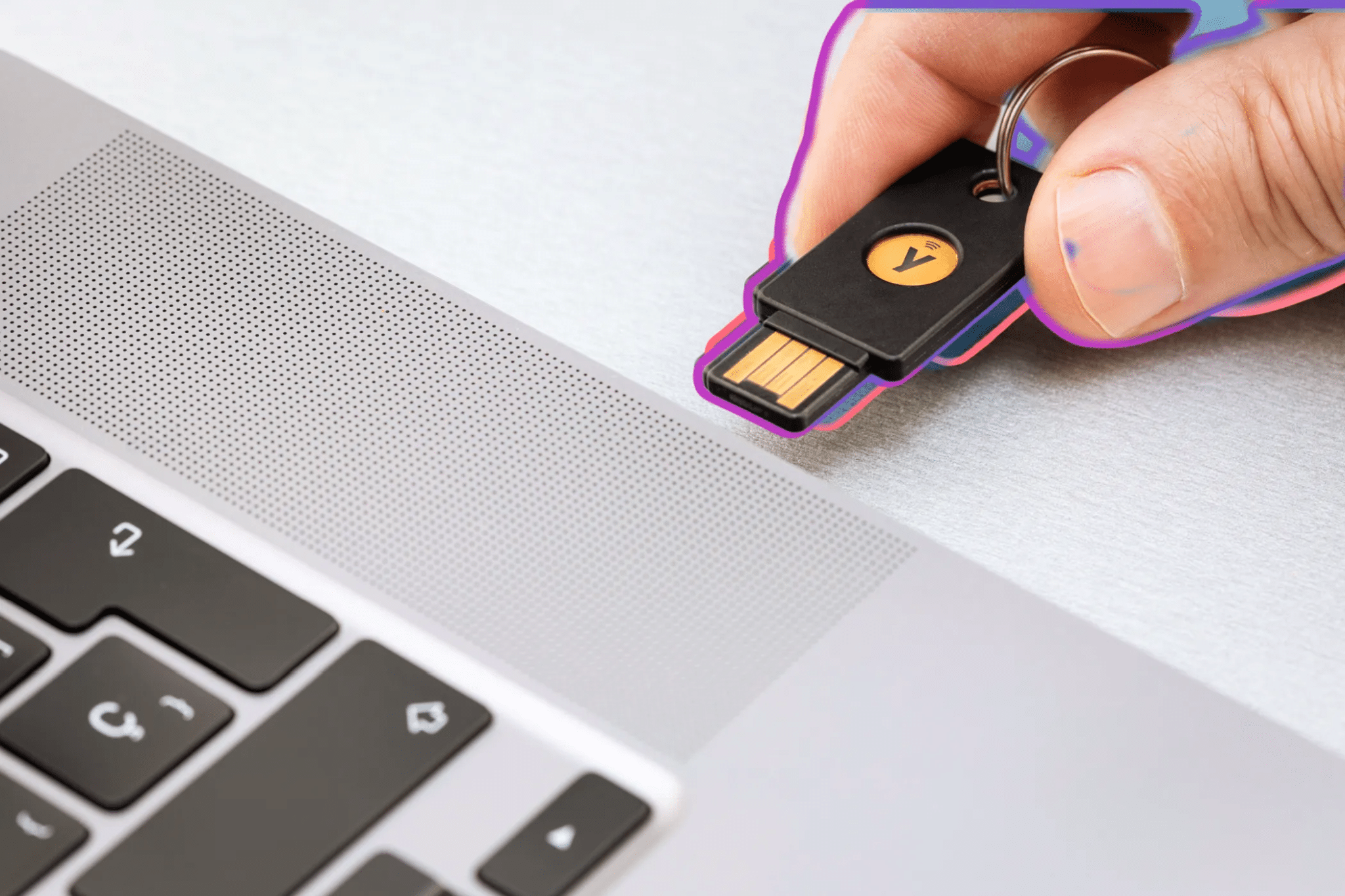 شخص يقوم بإدخال مفتاح أمان مادي من Yubico في منفذ USB الخاص بالكمبيوتر المحمول