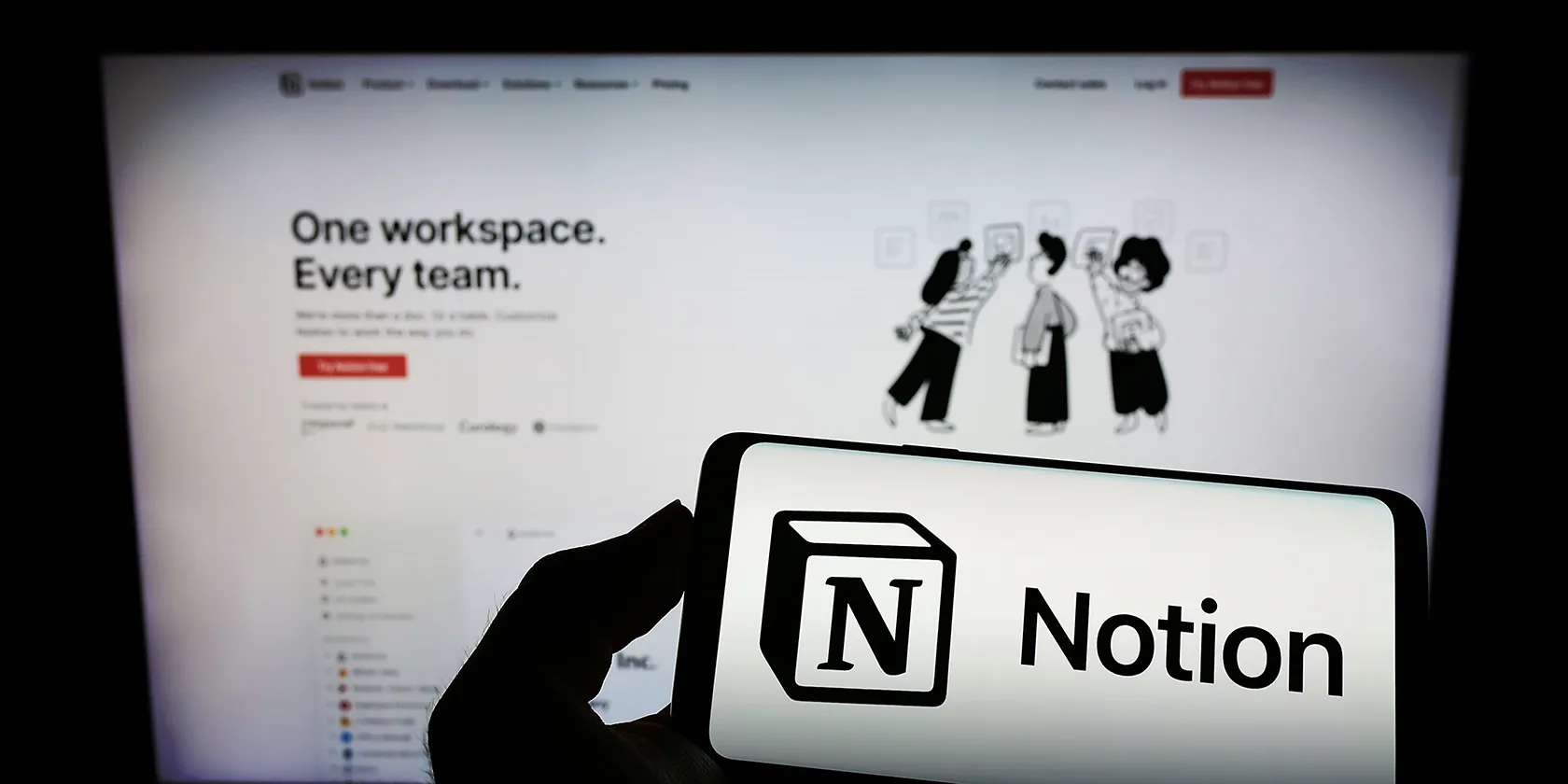 A phone and a monitor displaying the Notion interface and logo
