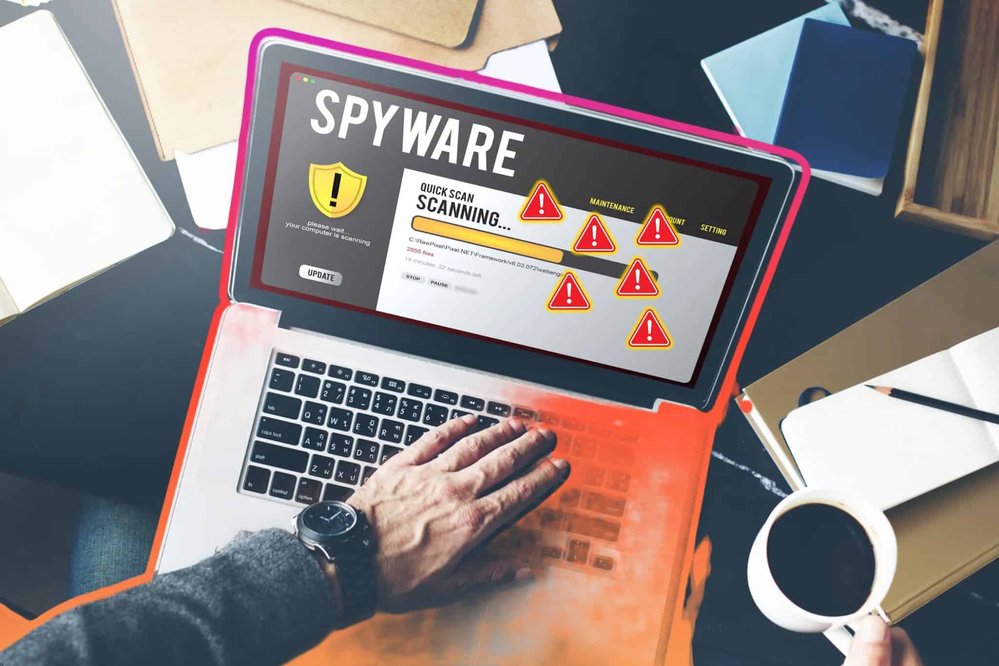 شخص يستخدم جهاز كمبيوتر محمول لفحص برامج التجسس مع علامات تحذير