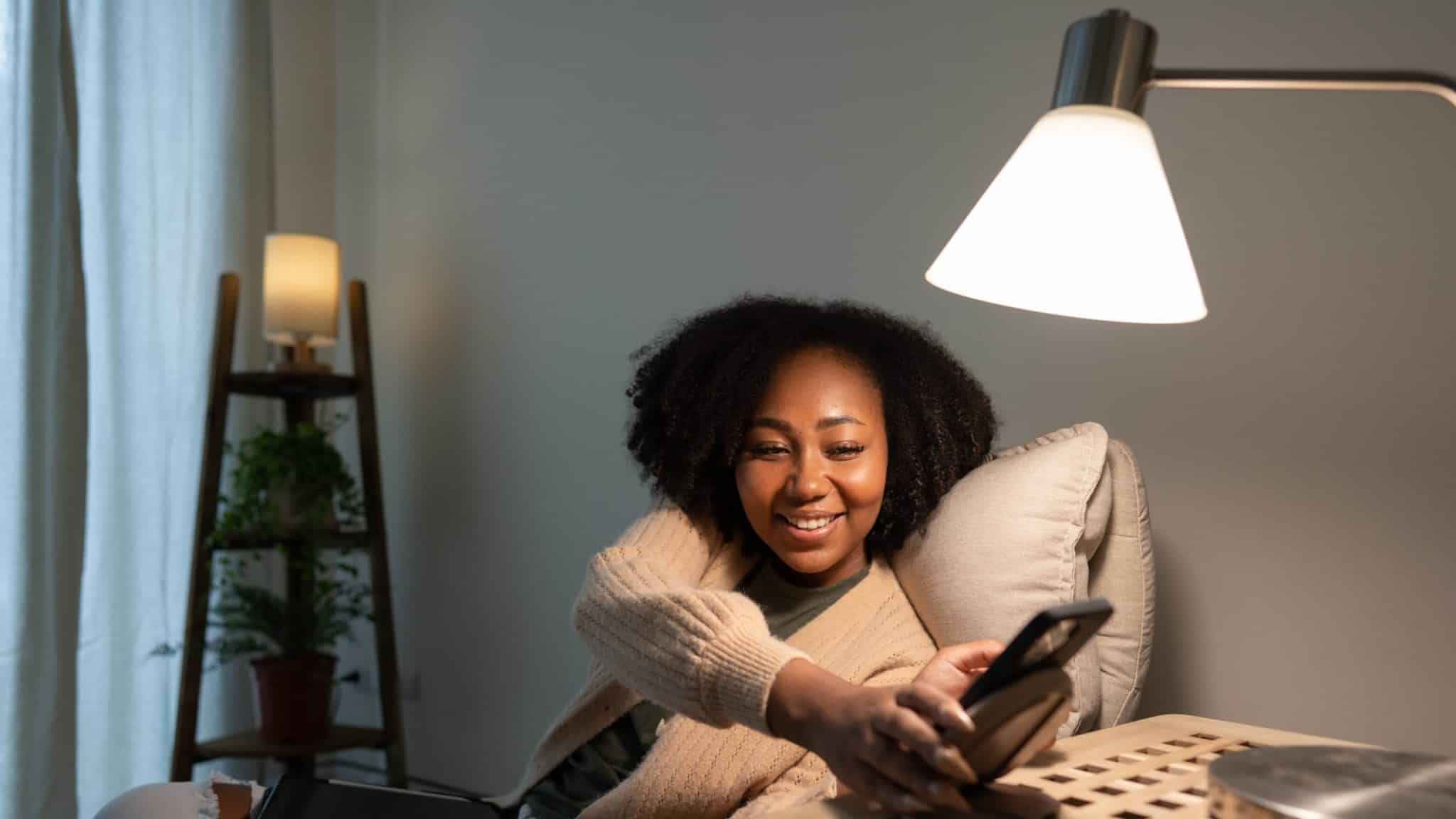 امرأة تنظر إلى الهاتف تحت مصباح