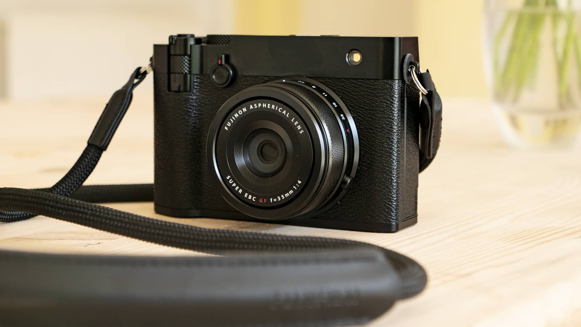 كاميرا Fujifilm GFX100RF سوداء بالكامل بنمط Rangefinder على طاولة خشبية