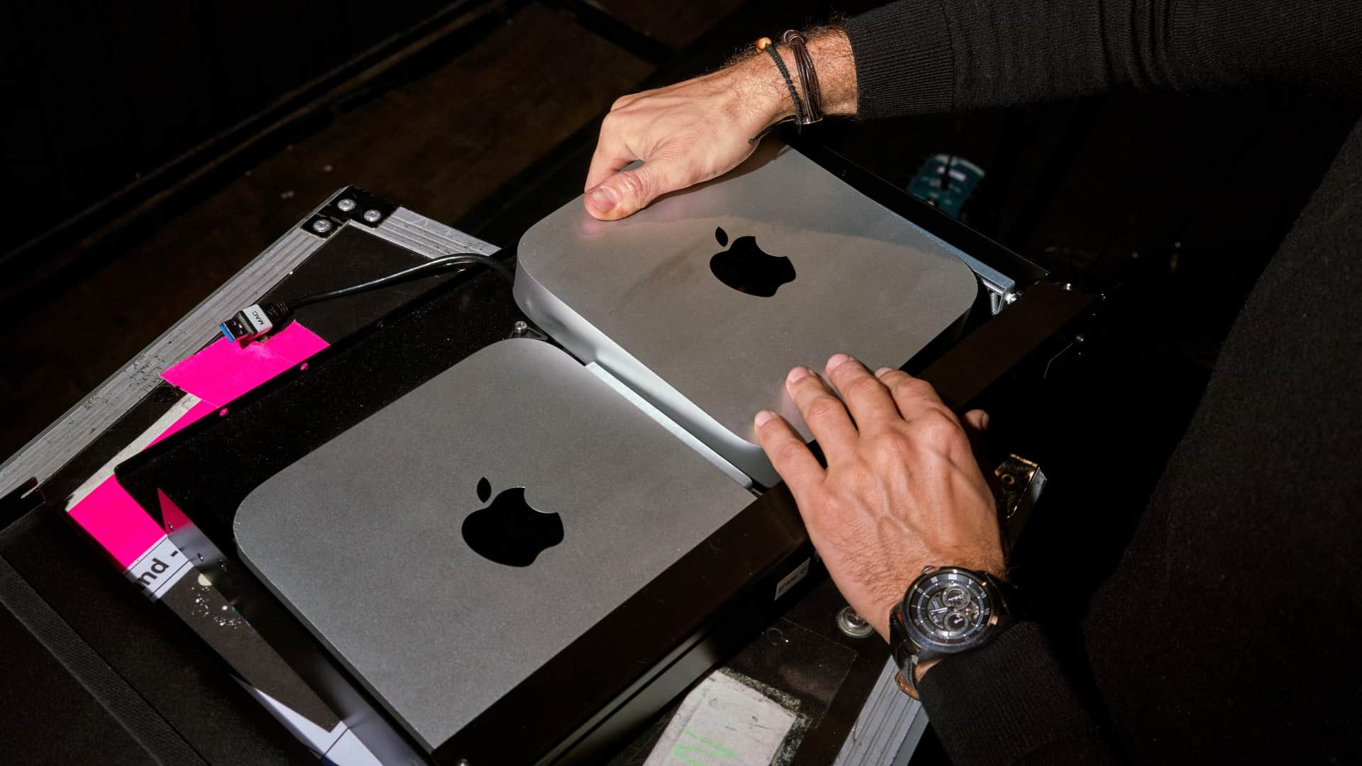 A person with two Apple Mac minis in a bag.