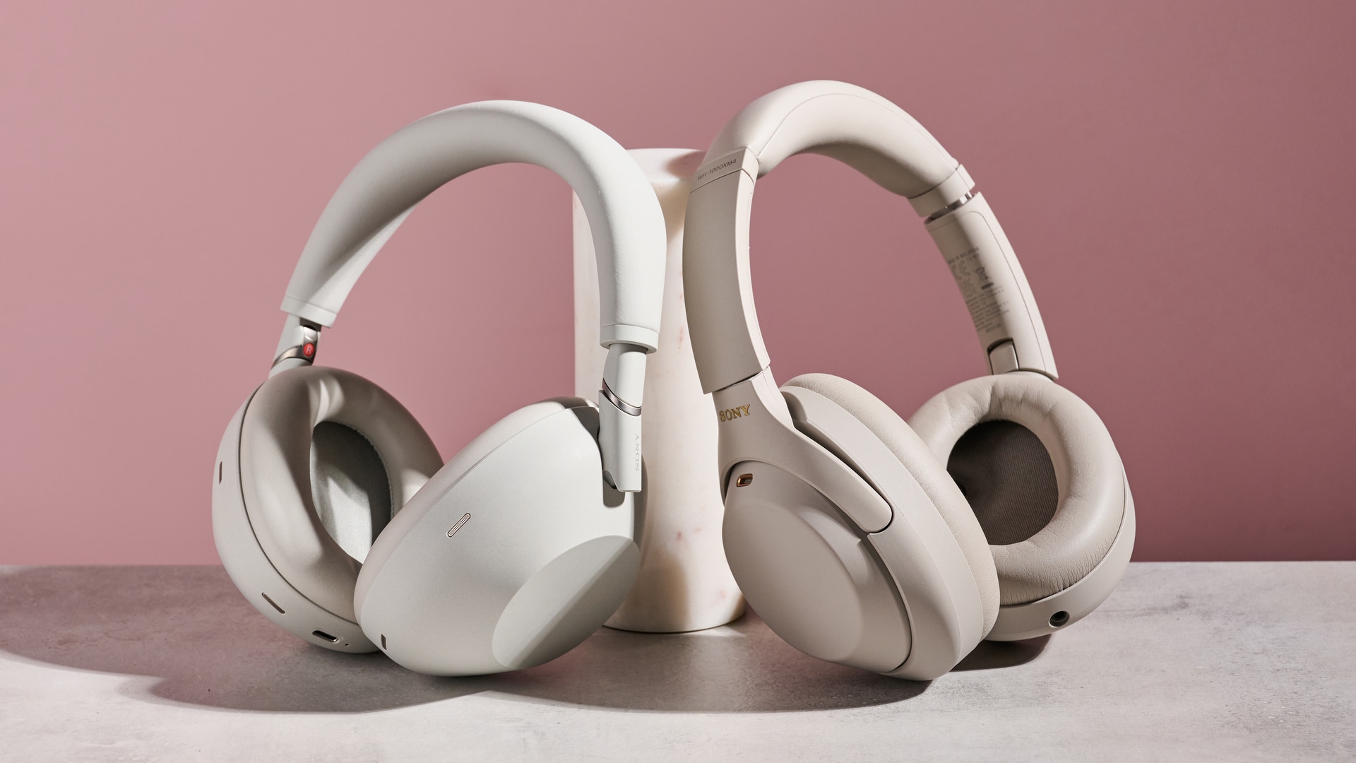 Sony WH-1000XM6 and Sony WH-1000XM4, both leaning against a cylindrical post