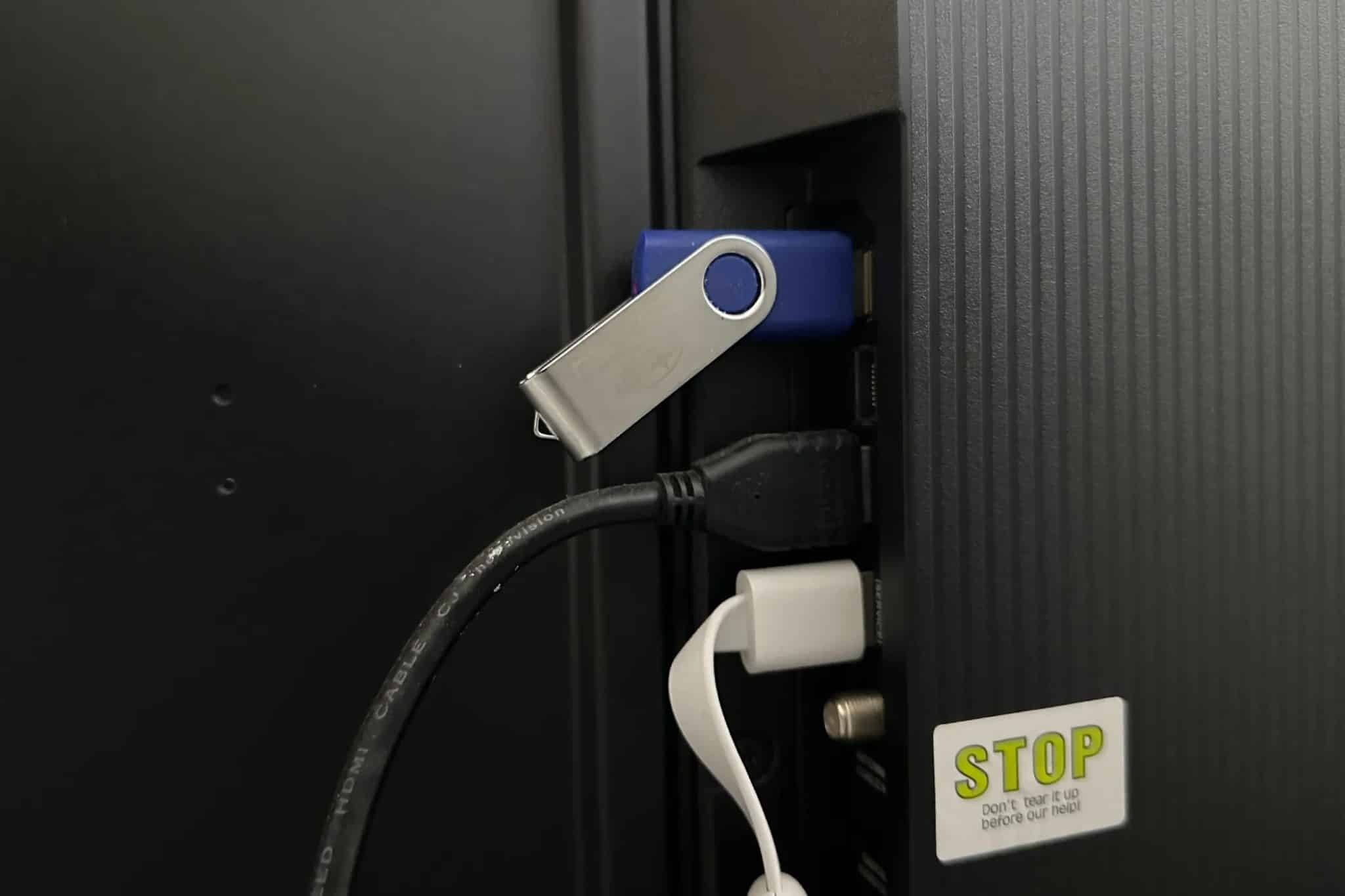 a USB drive containing videos attached to a TV