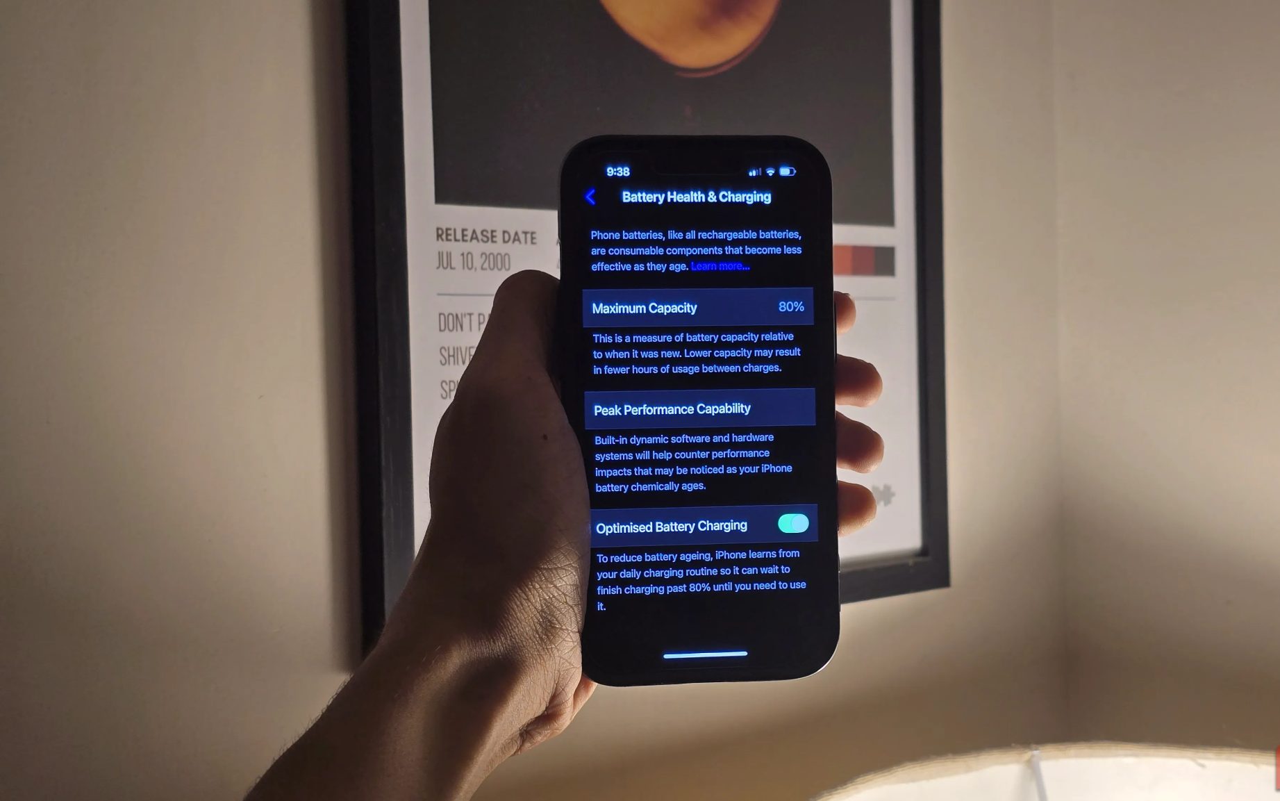 شخص يحمل جهاز iPhone مع فتح قائمة صحة البطارية والشحن