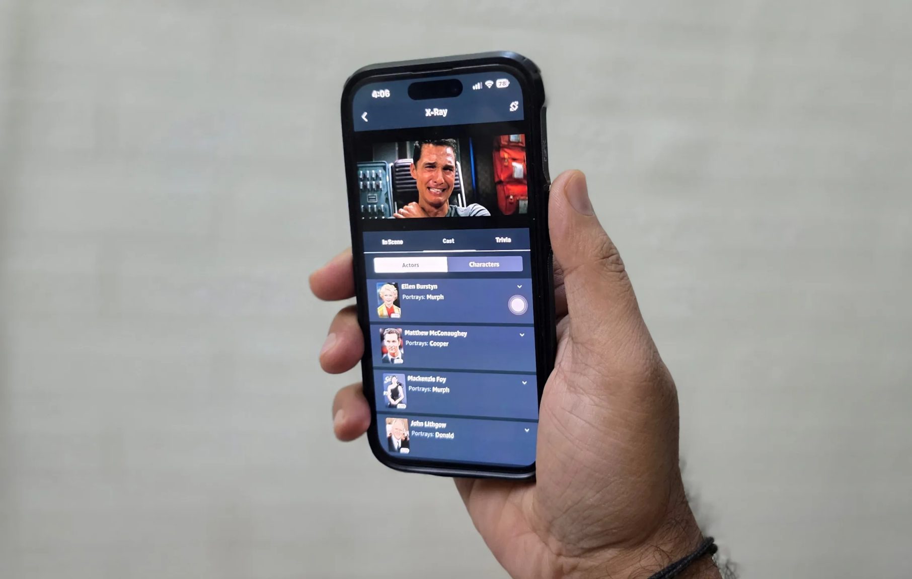 رجل يحمل هاتف iPhone ويشاهد فيلم Interstellar على Prime Video