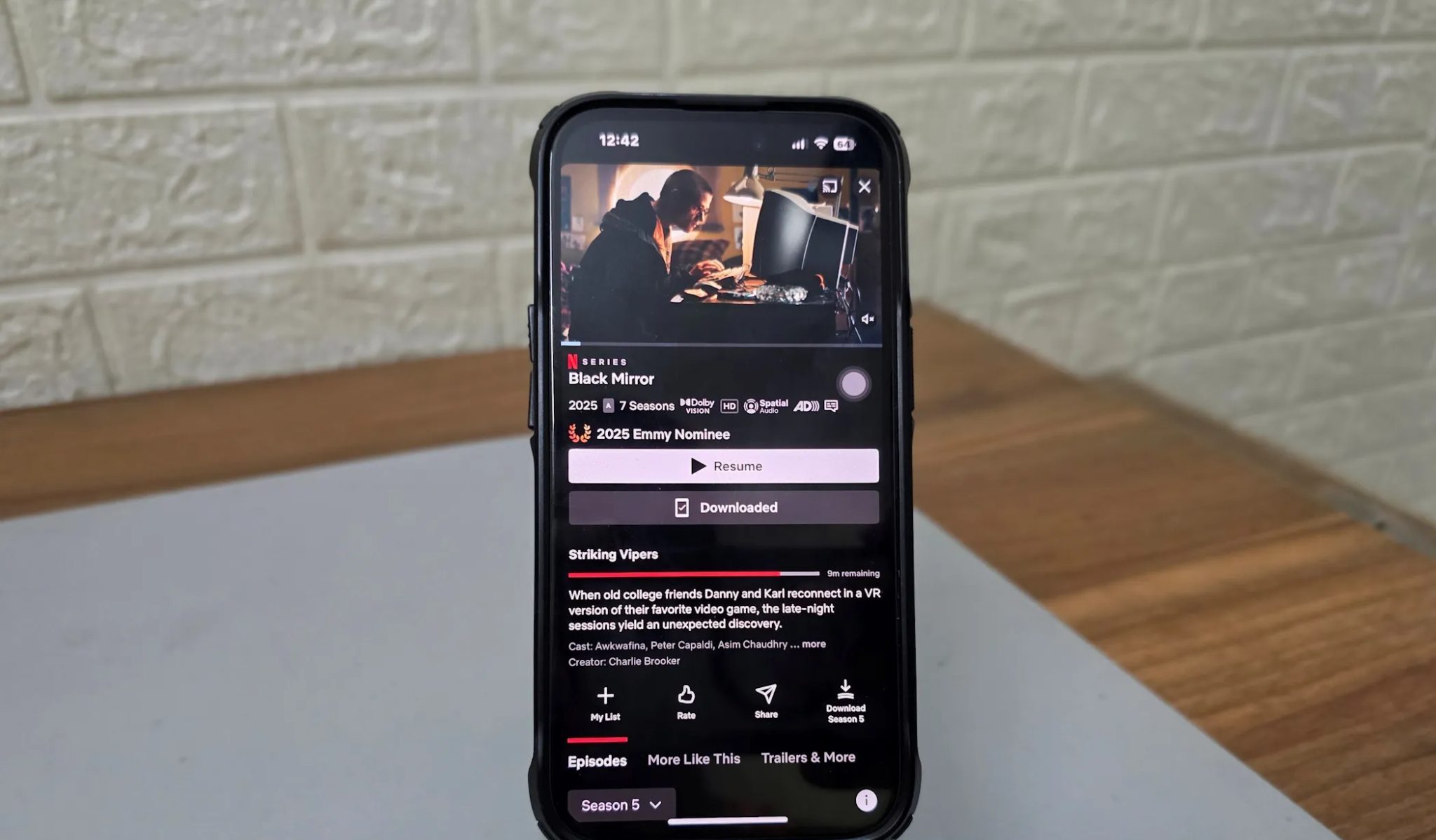 A phone holder holds an iPhone with Netflix open