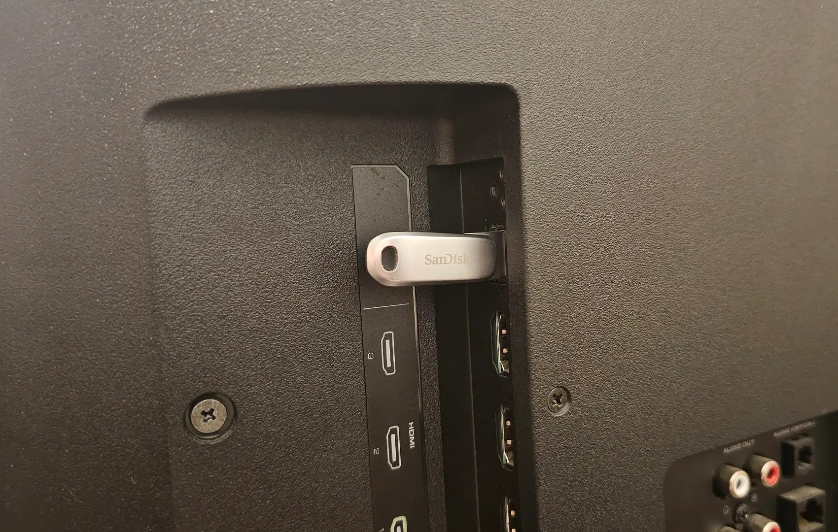 A SanDisk USB stick plugged into a Vizio smart TV's USB port