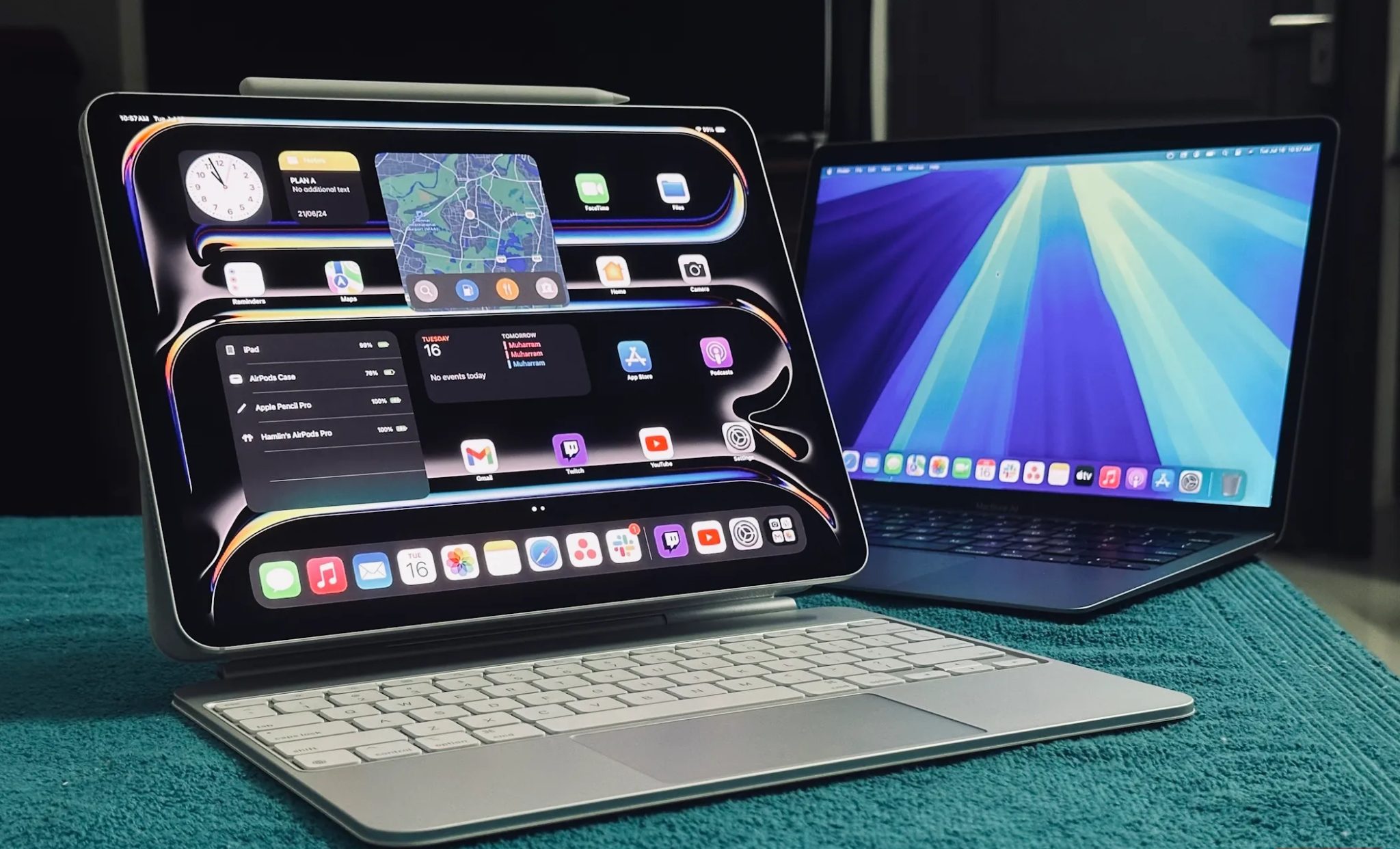 جهاز iPad Pro متصل بلوحة مفاتيح Magic Keyboard بجوار جهاز MacBook على طاولة