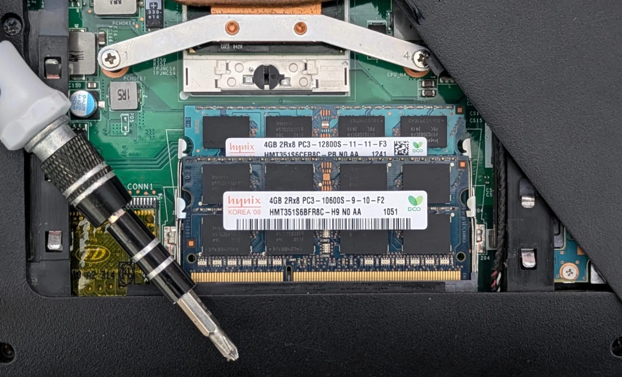 Laptop RAM in open laptop with a screwdriver.