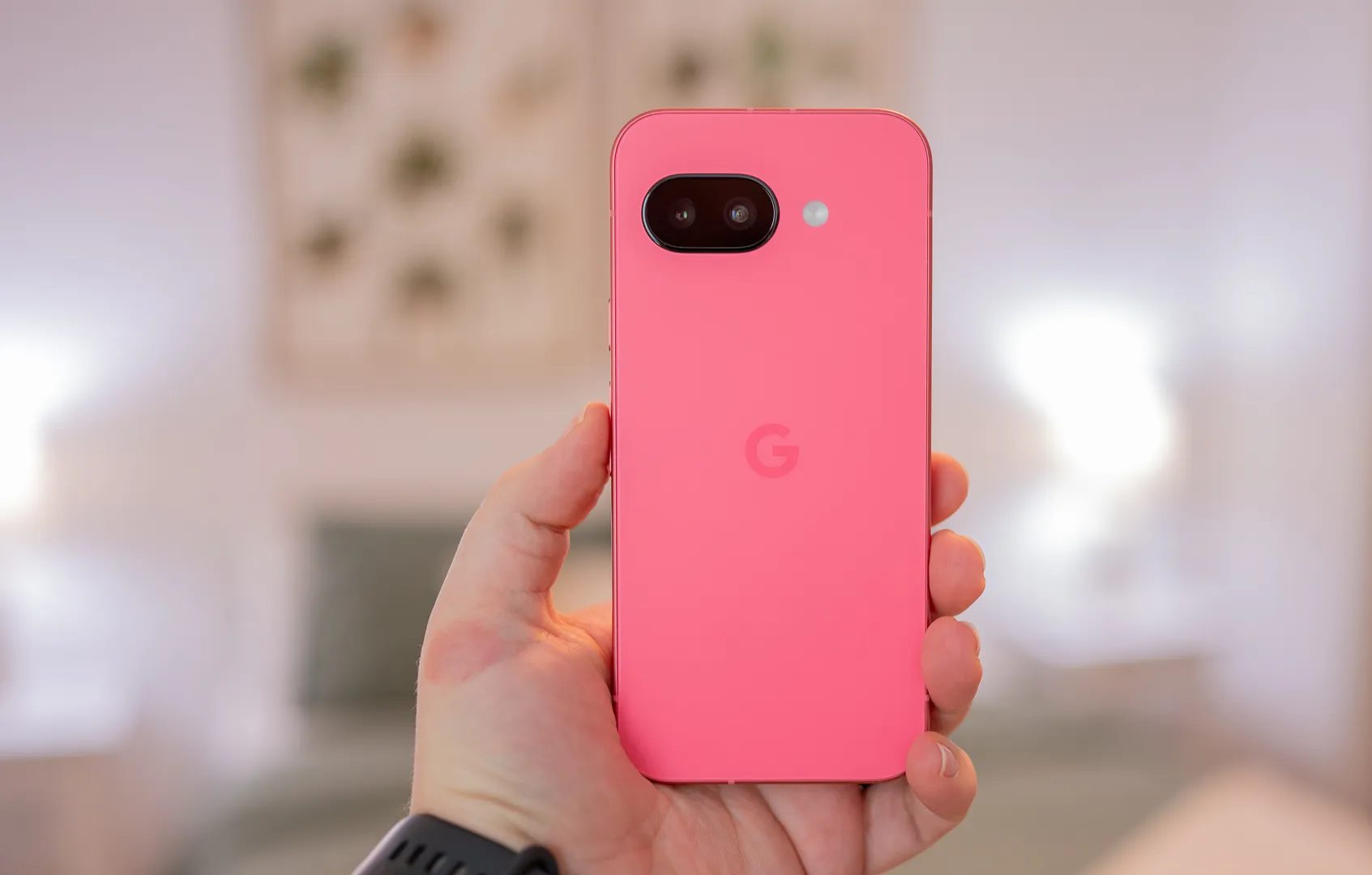 شخص يحمل هاتف Google Pixel 9a ويظهر الجزء الخلفي من الهاتف