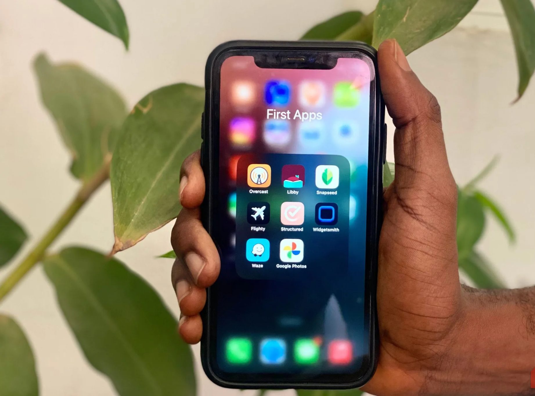 يد تحمل iPhone تعرض مجموعة تطبيقات