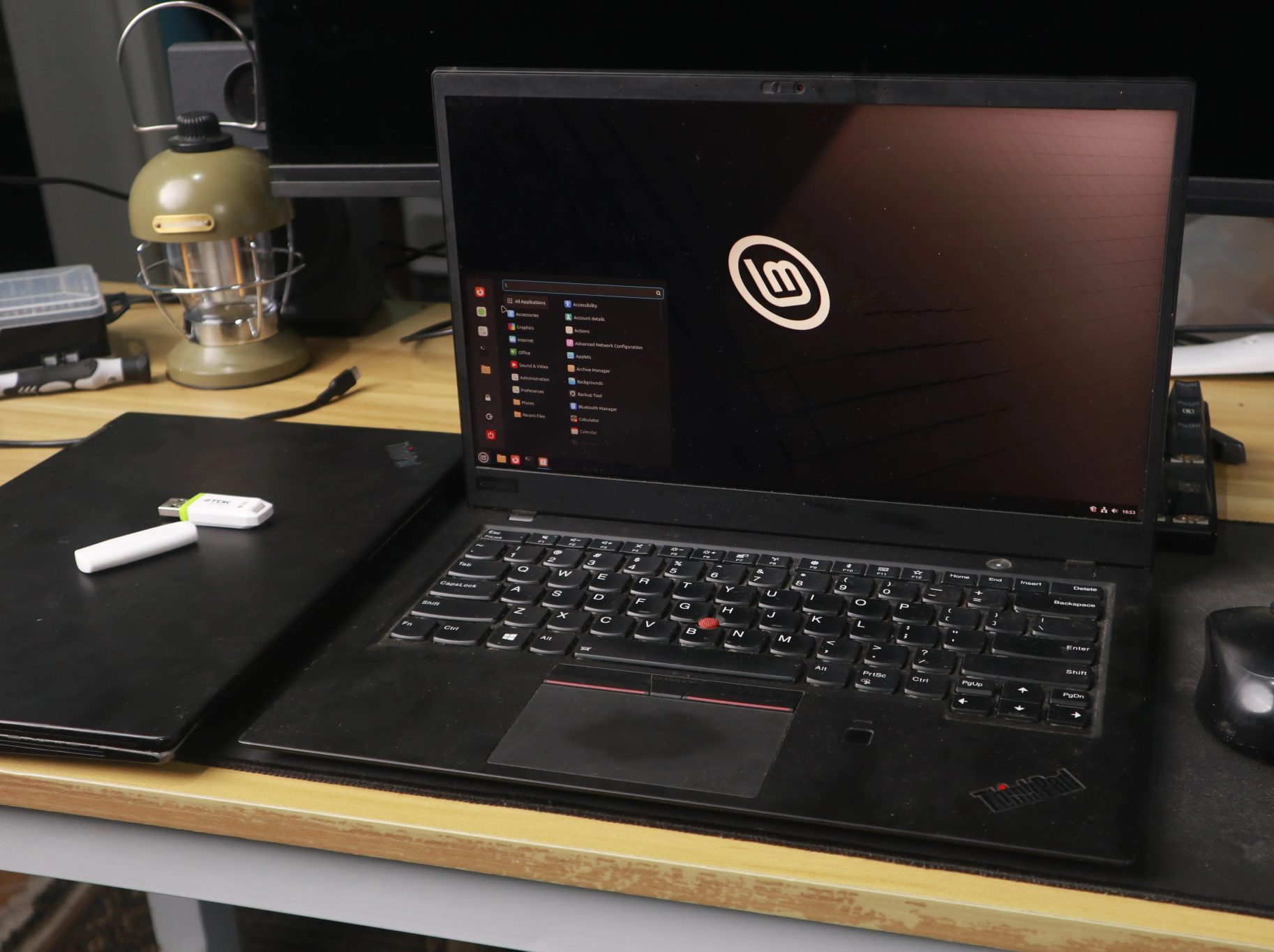 Linux Mint desktop on a ThinkPad laptop, with a mouse and USB stick nearby