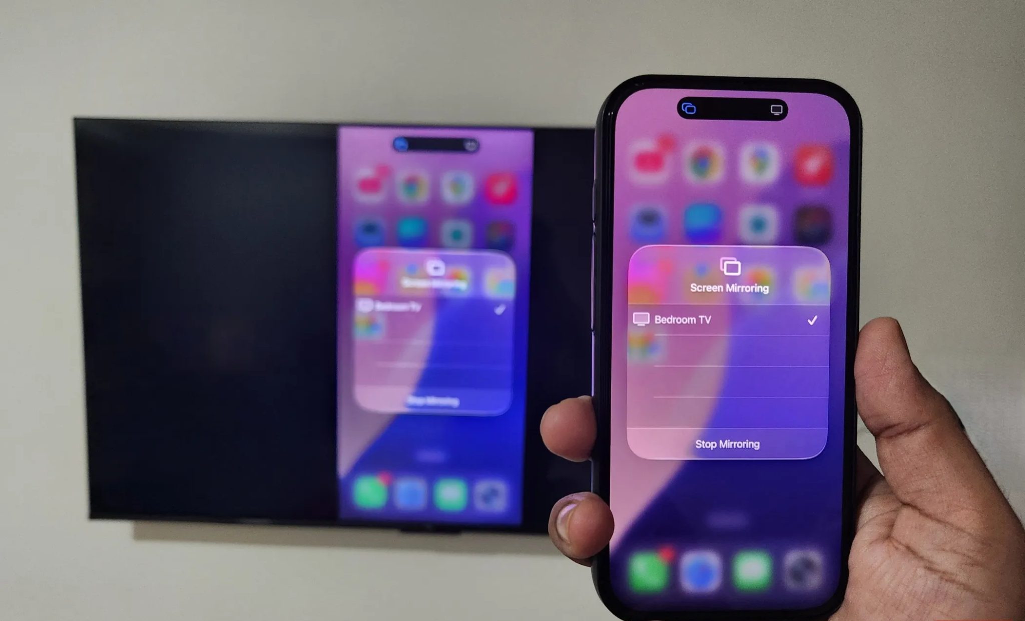iPhone in hand mirroring screen to TV