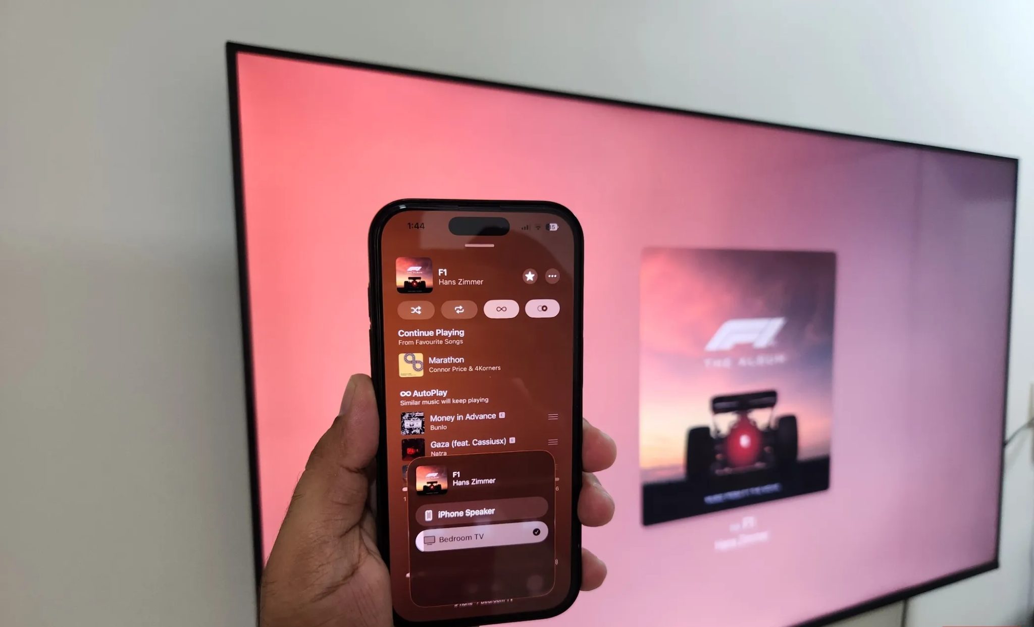 iPhone in hand playing song on Google TV using AirPlay