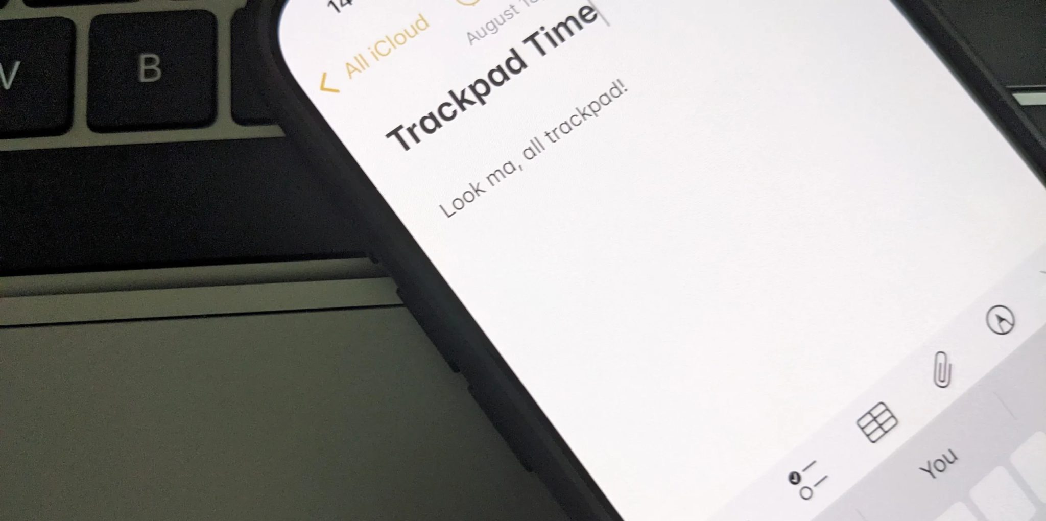 اللوحة اللمسية في iPhone معروضة في تطبيق Notes على لوحة لمس MacBook