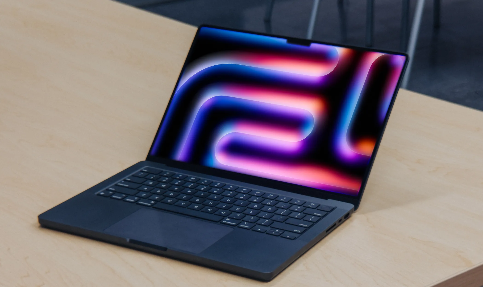 شاشة M4 MacBook Pro مائلة للخلف على طاولة خشبية