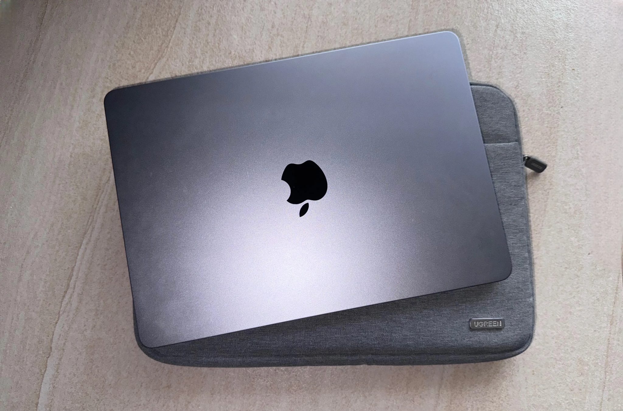 MacBook and a Ugreen sleeve on a flat surface.
