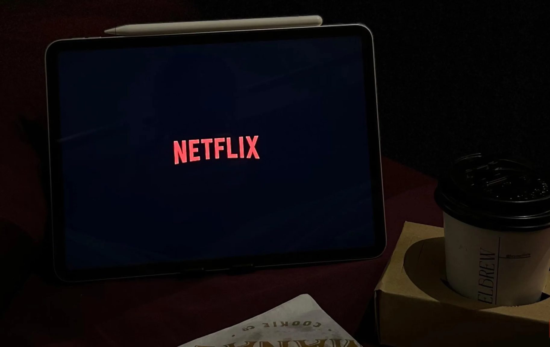 شاشة Netflix على جهاز iPad بجوار فنجان قهوة