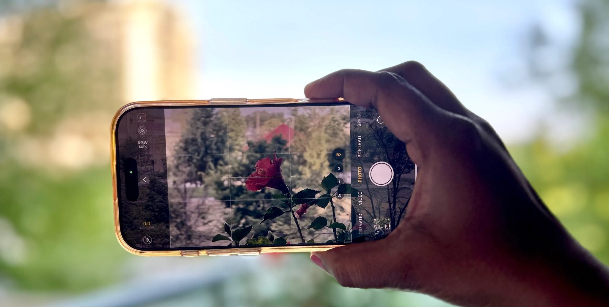 يد تحمل هاتف iPhone يظهر تقريب 5x