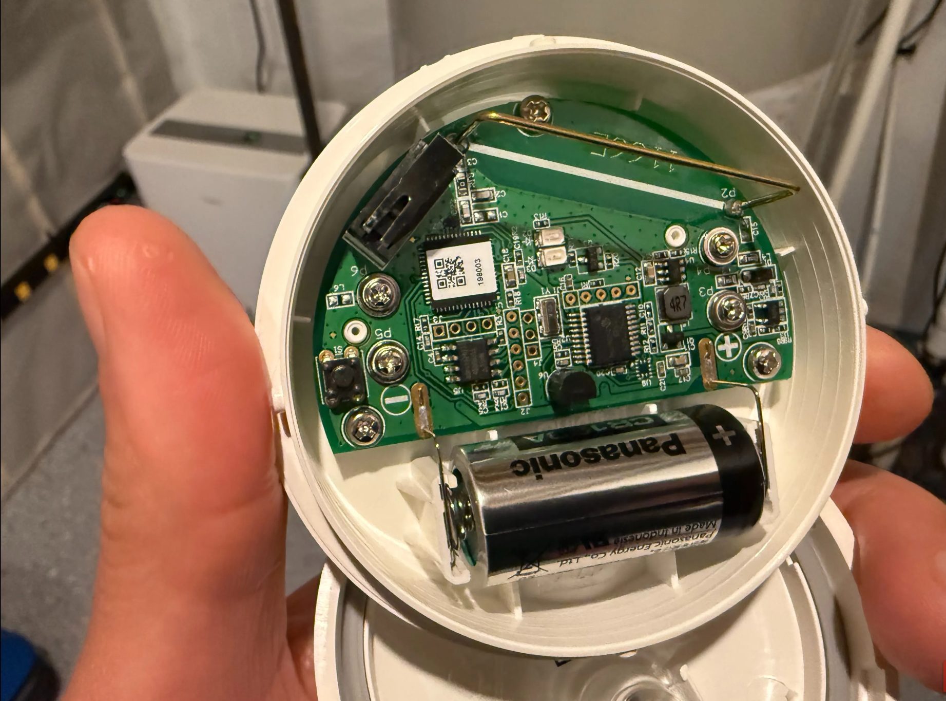 يد تحمل مستشعر الفيضان والتجمد من Ring تُظهر اللوحة الإلكترونية