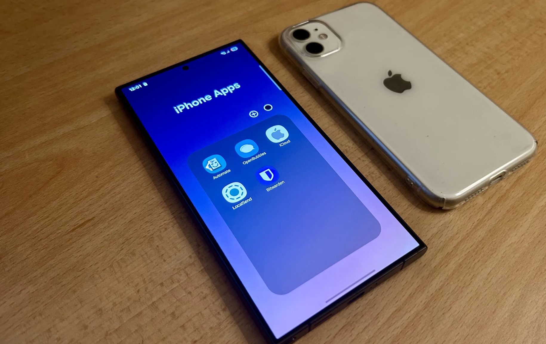 هاتف Samsung Galaxy S24 Ultra مع مجلد تطبيقات مفتوح بجوار iPhone 11