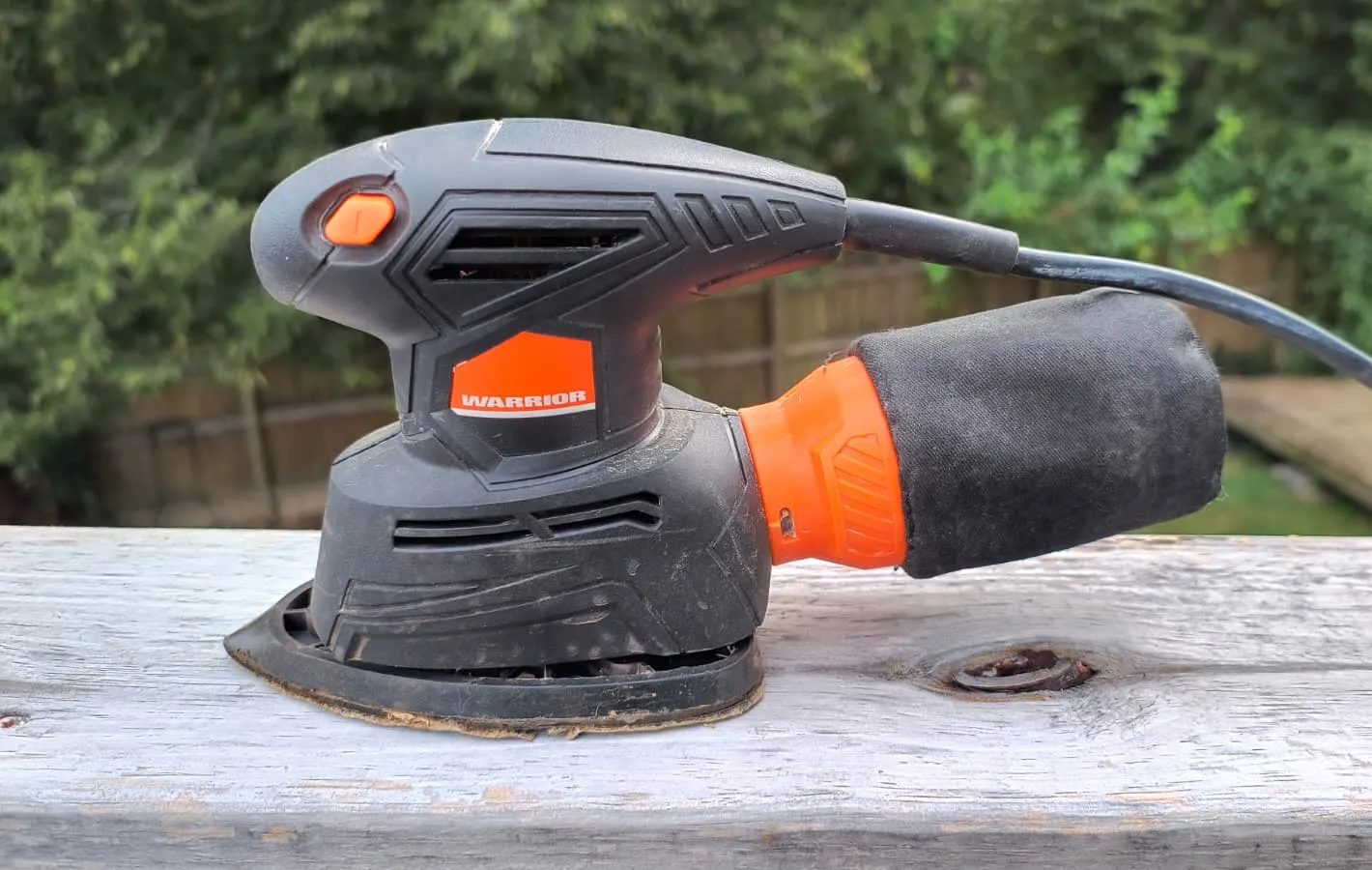 A small electric sander on a wooden rail