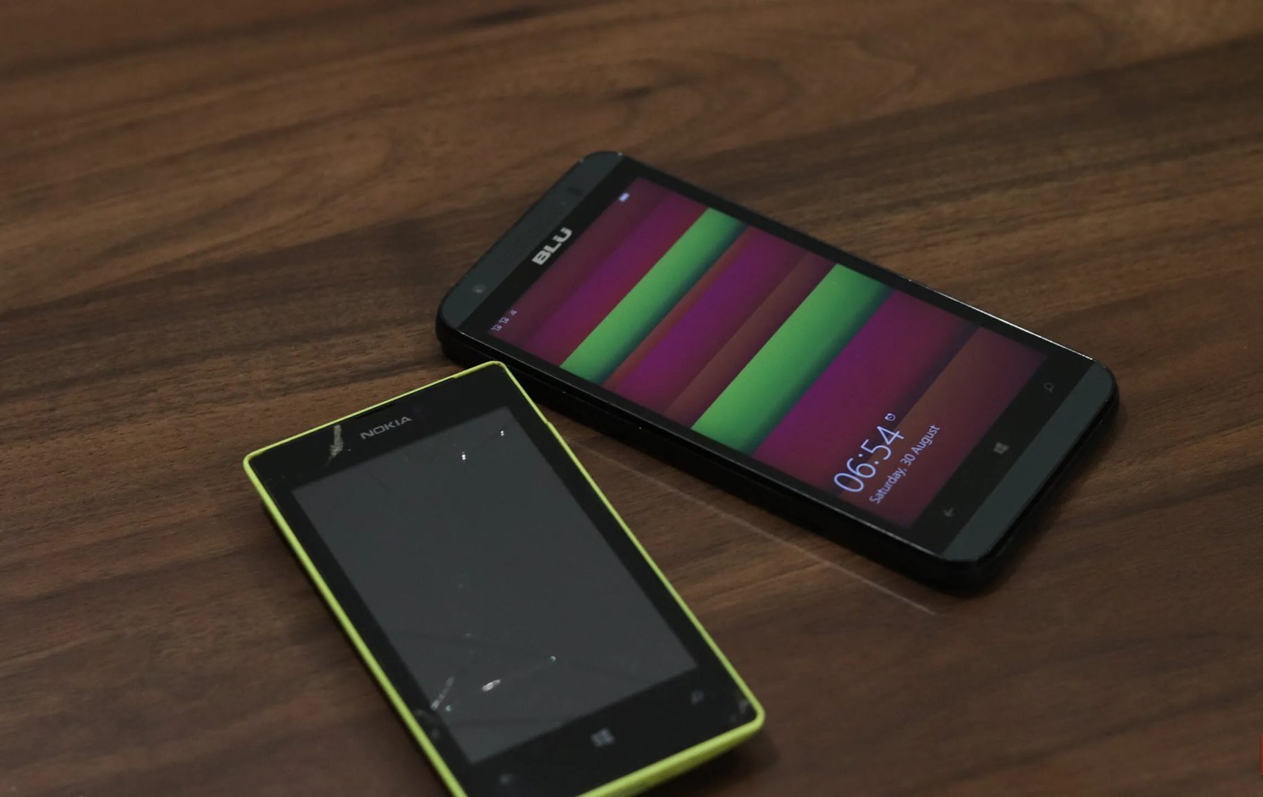 هاتفان يعملان بنظام Windows Phone موضوعان على مكتب.