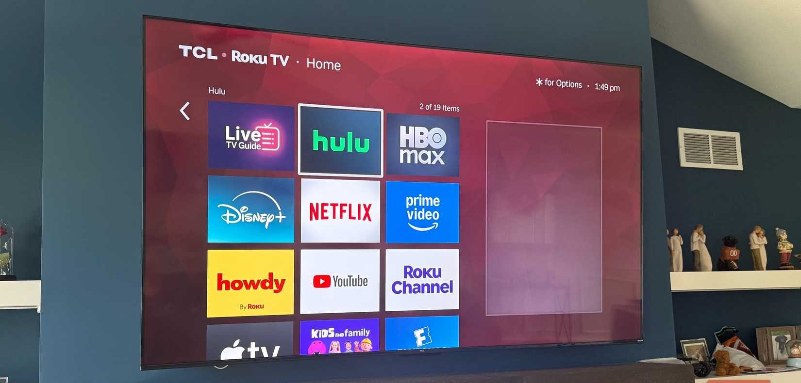 تلفزيون ذكي Roku TCL مقاس 75 بوصة مثبت على حائط أزرق