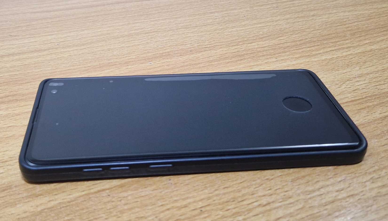 واقي شاشة بفتحة ماسح بصمات الأصابع أعلى هاتف Samsung على طاولة.