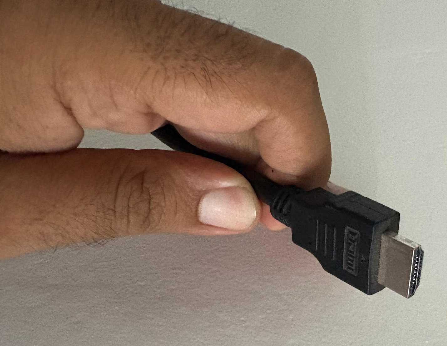 A man holding an HDMI cable