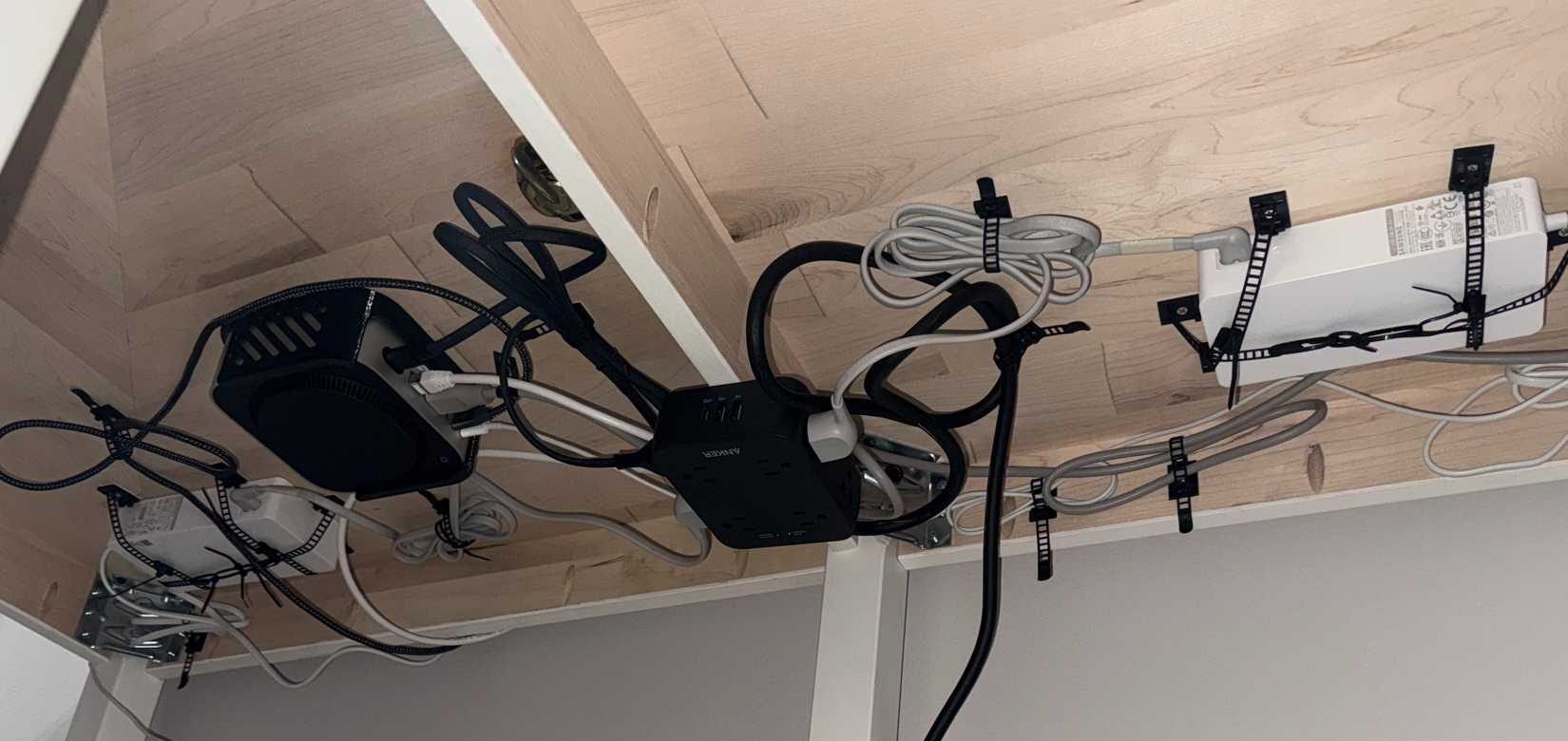 شريط طاقة Anker مثبت تحت المكتب مع رؤية جهاز Mac Mini