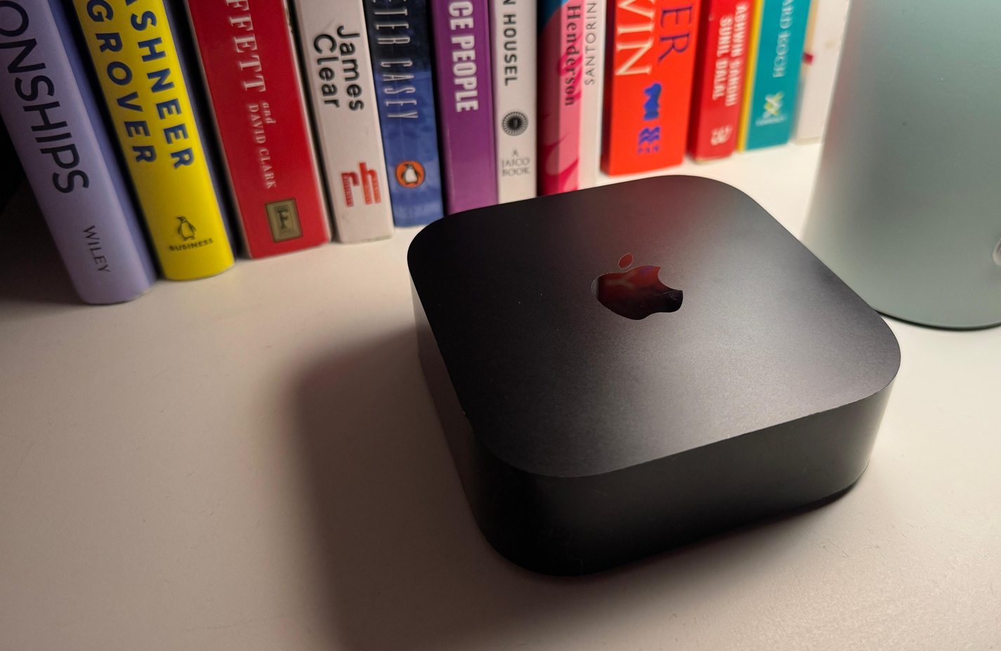 جهاز Apple TV مع بعض الكتب في الخلفية