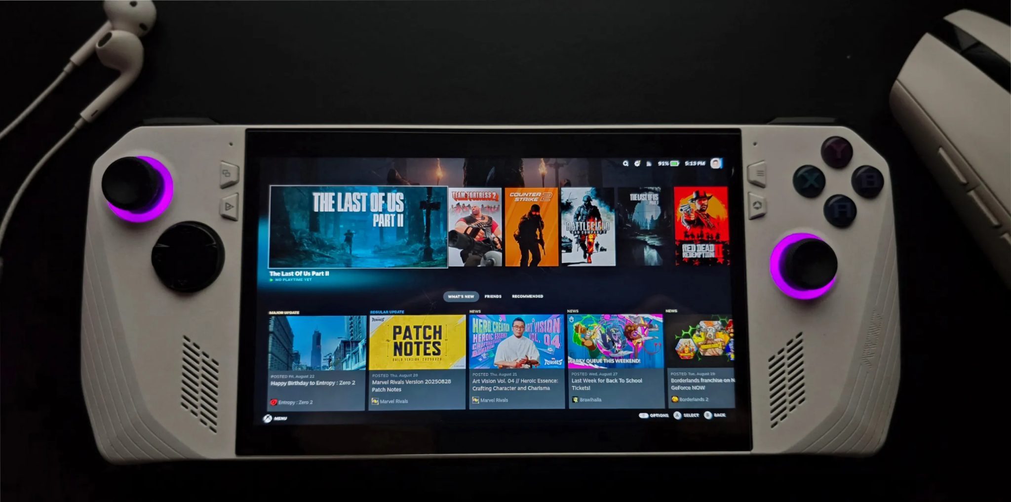 ASUS ROG Ally running SteamOS with earphones and a mouse in the background
