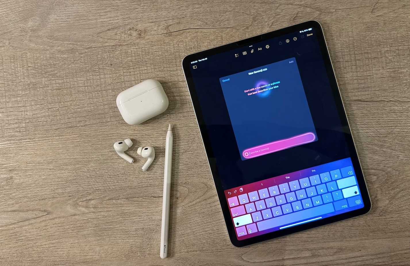 شاشة Genmoji على جهاز iPad، بجانب AirPods وقلم Apple Pencil