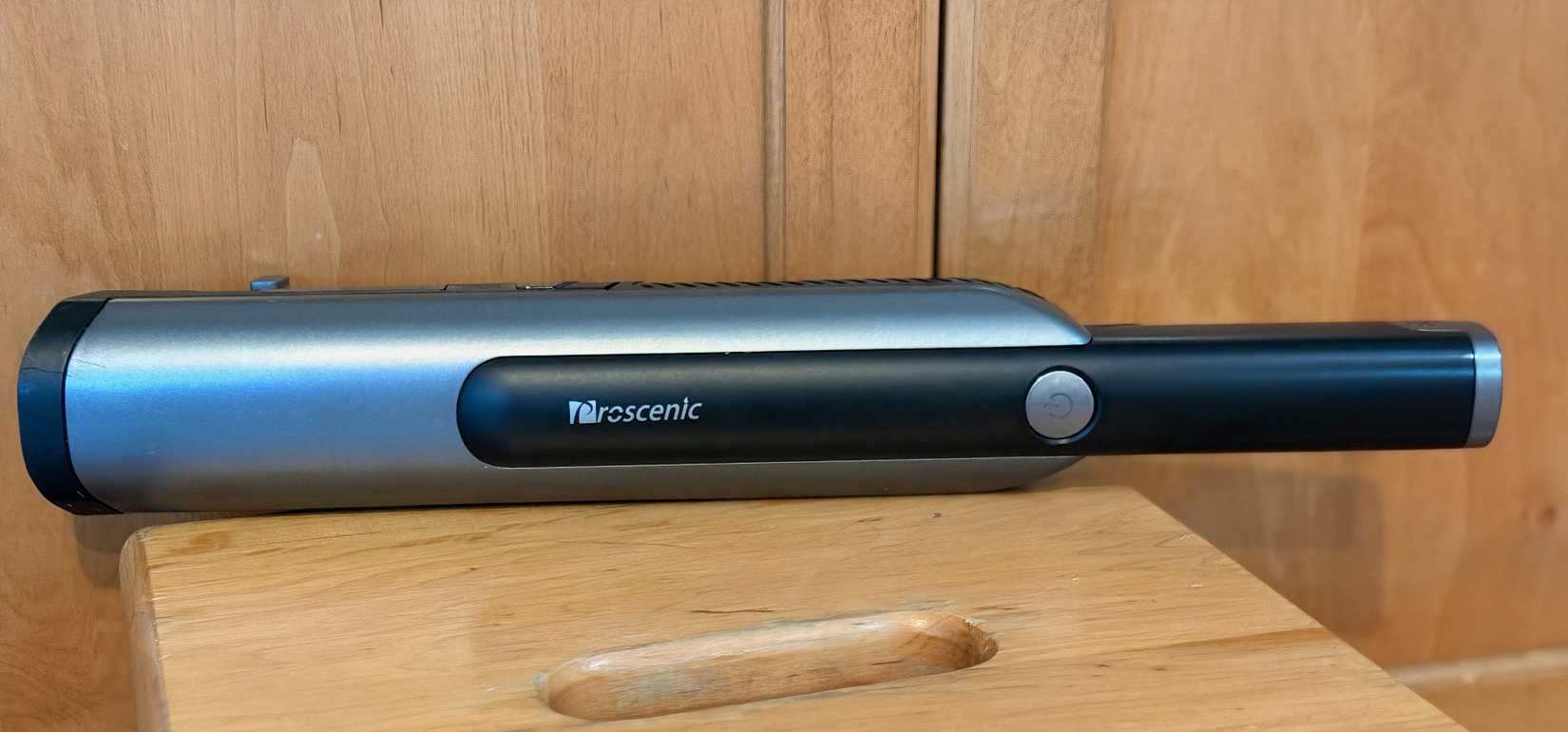 A black hand-held vaccum sitting on a surface.