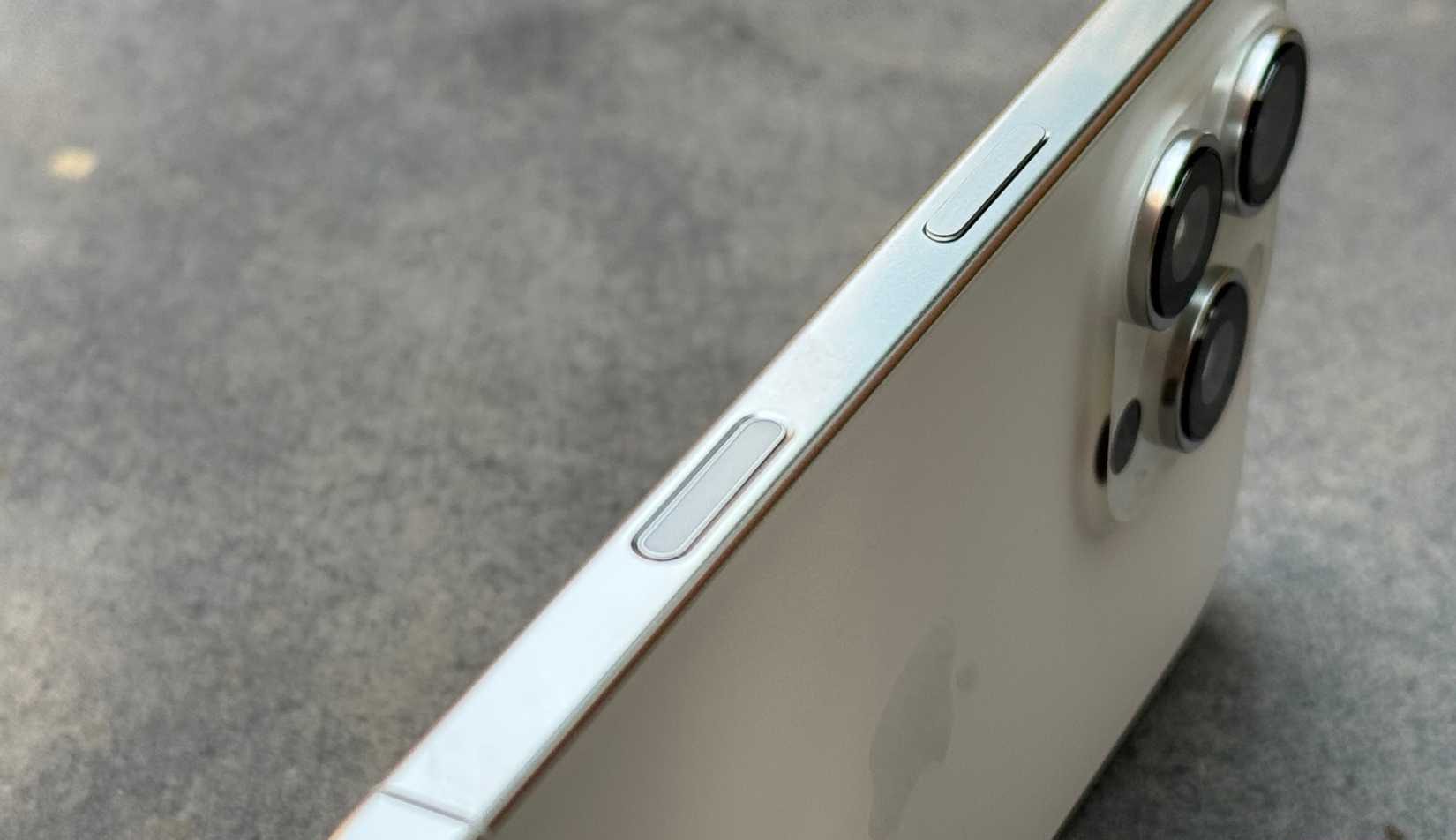 iPhone 16 Pro kept on a stone slab with focus on its right edge with the camera control button