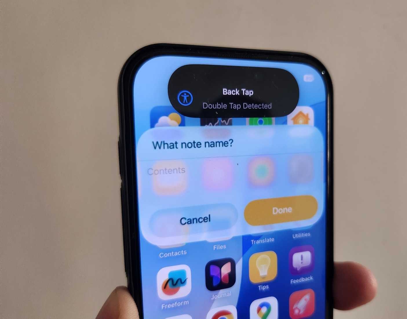 iPhone 16 Pro في اليد يظهر تنبيه Back Tap مفعل