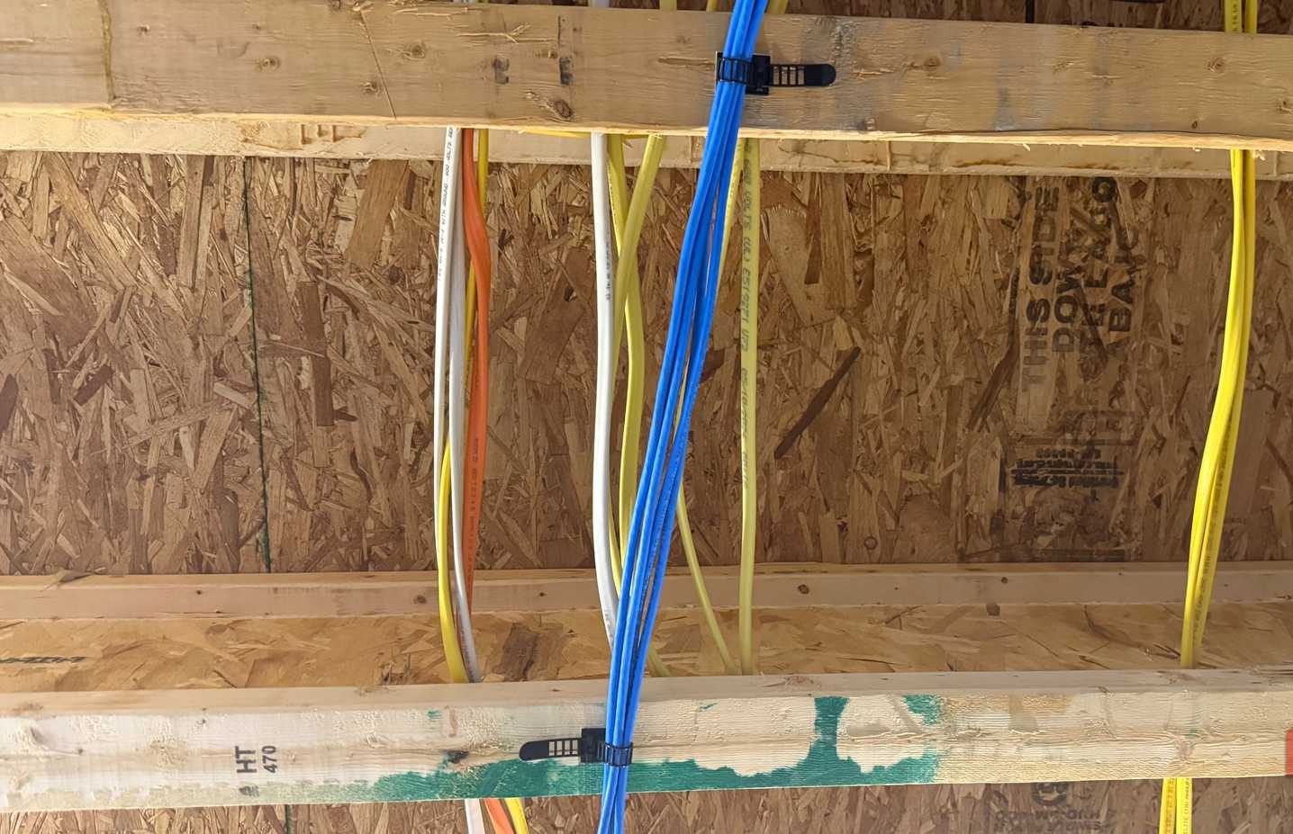 عدة كابلات Cat6 مثبتة بالجزء السفلي من روافد الأرضية في سقف القبو