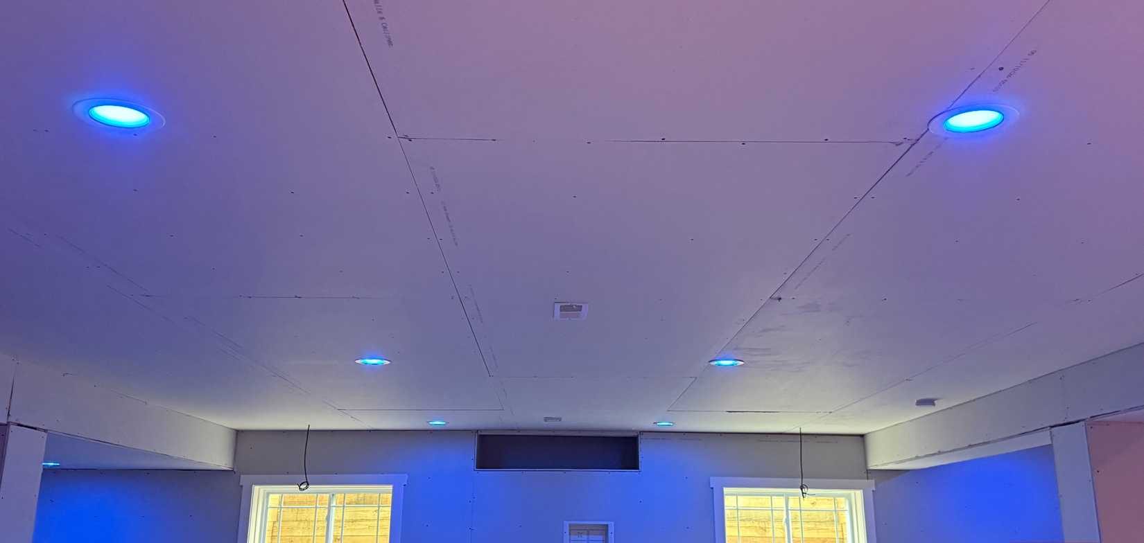 أضواء Philips hue زرقاء في غرفة معيشة كبيرة في الطابق السفلي