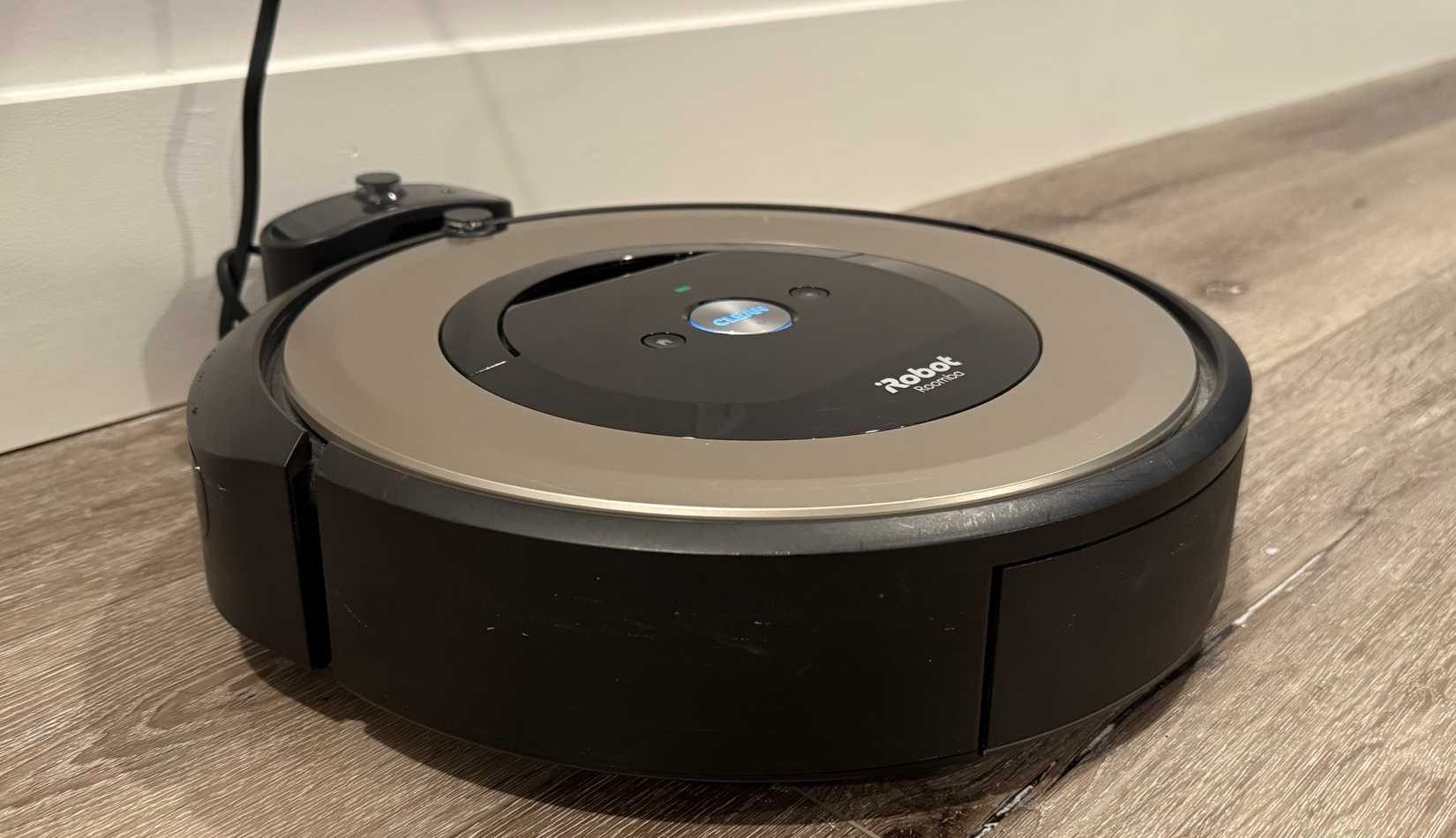 مكنسة روبوتية على الأرض متصلة بالشاحن