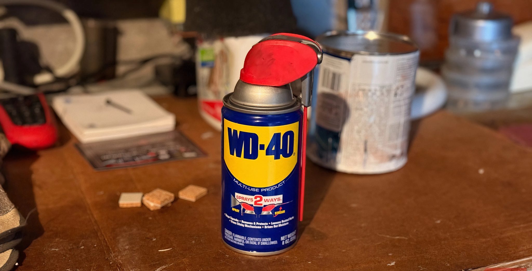 علبة WD-40 موضوعة على طاولة عمل في المنزل.