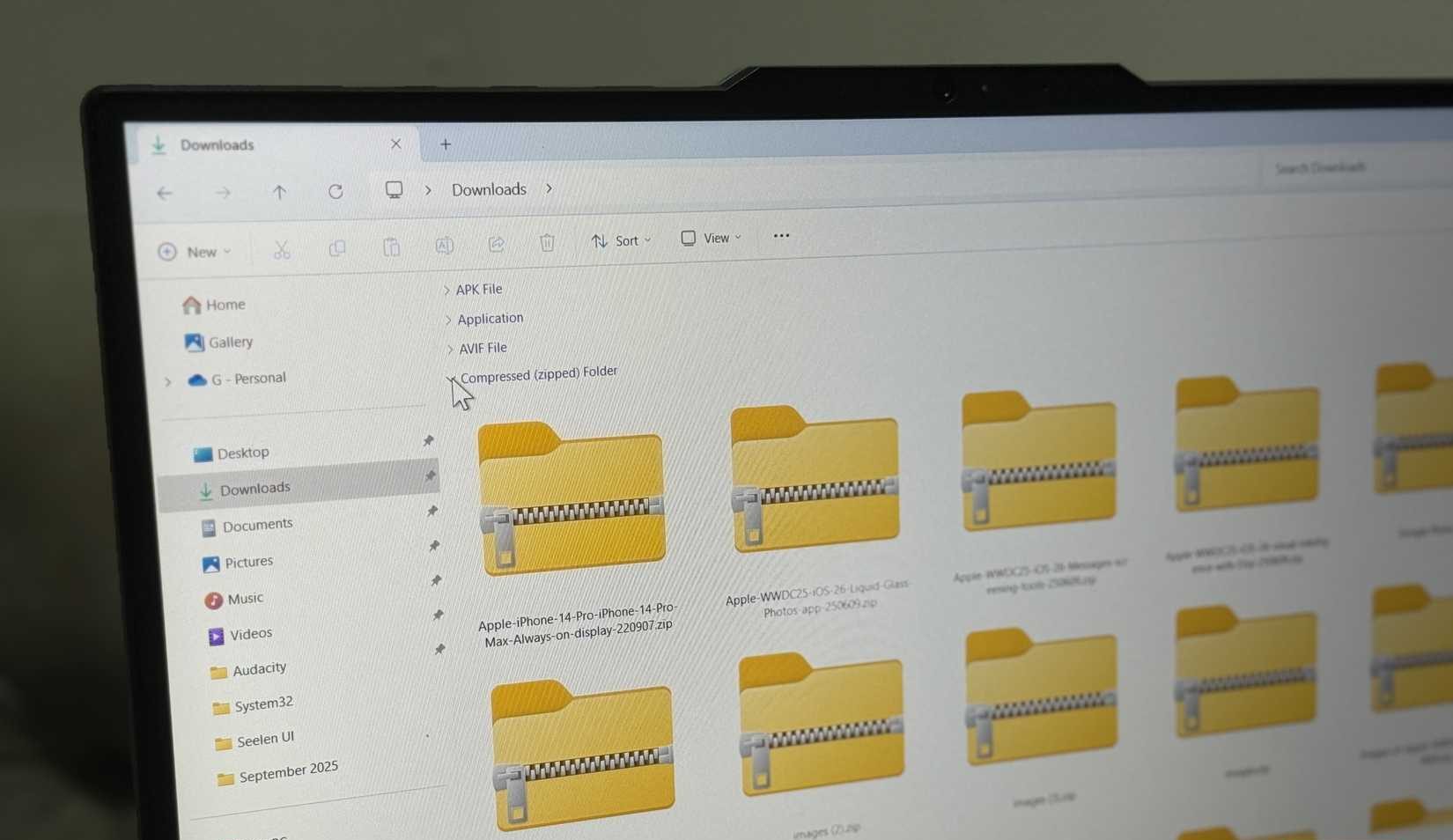 Windows laptop showing downloads folders with zip files