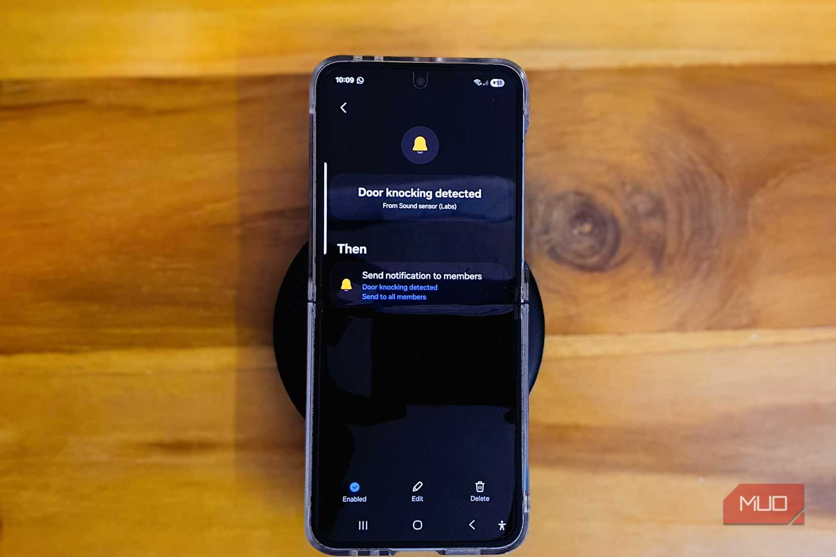 هاتف Samsung Galaxy Z Flip 6 موضوع على طاولة خشبية مع لوحة مفاتيح على الحافة