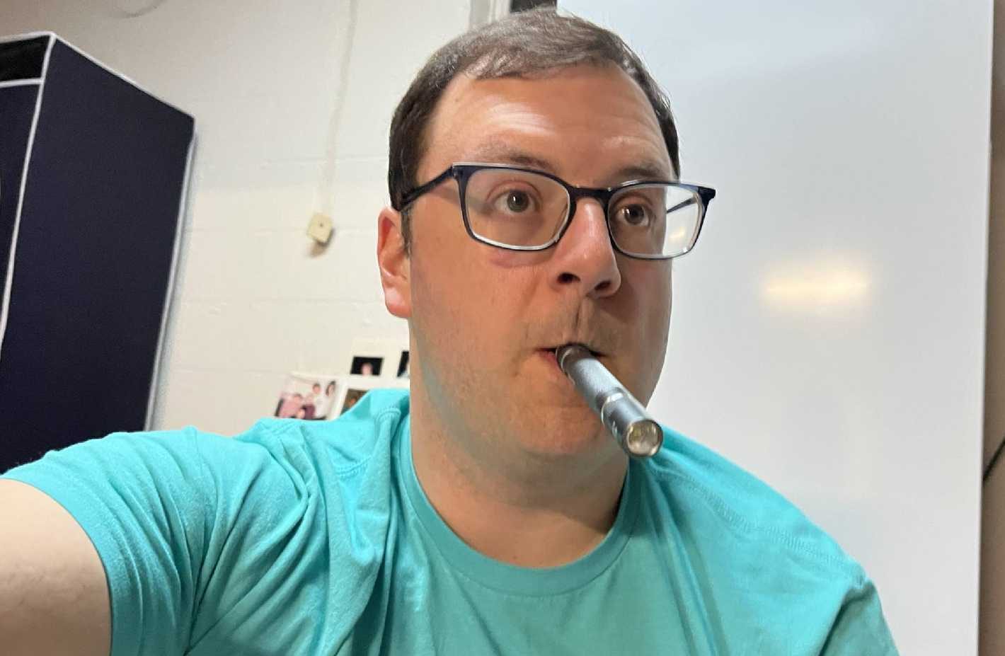 قلم إضاءة يُمسك بالفم أثناء العمل