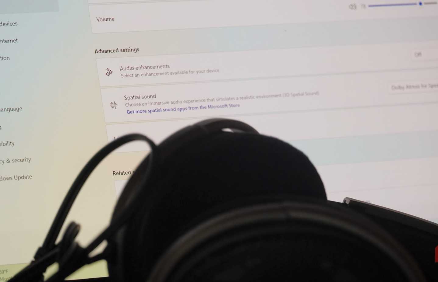 Audio enhancement settings behind a pair of over-ear headphones.